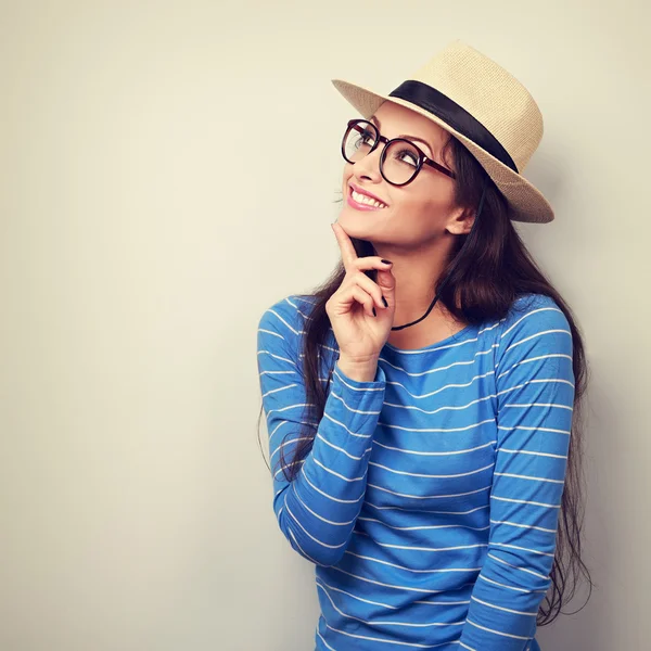 Happy thinking young woman looking up in fashion glasses and str