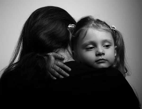 Family lifestyle. Daughter hugging her mother and looking serious