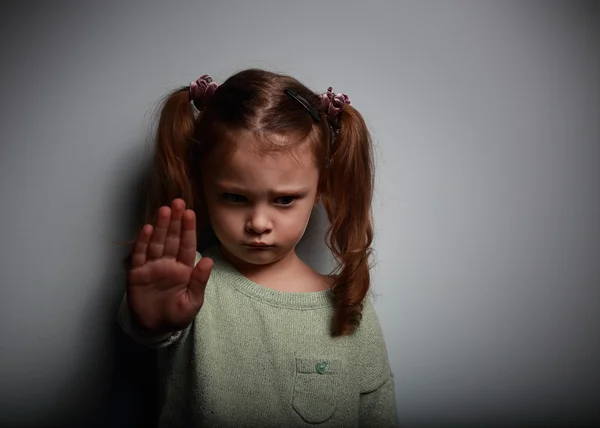 Kid girl showing hand signaling to stop violence and pain and lo