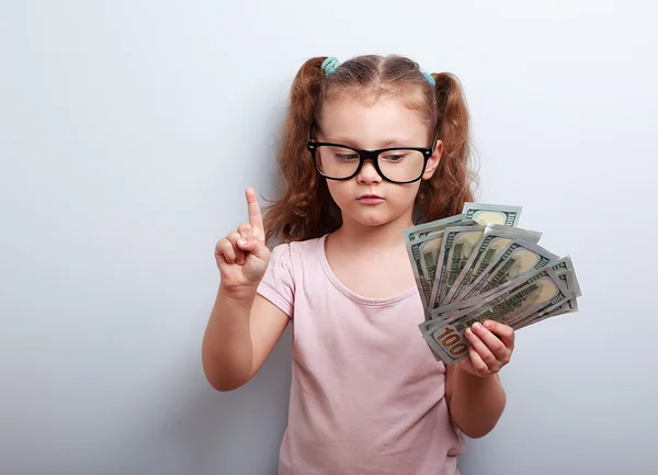Small kid girl holding dollars and have an plan how earning much