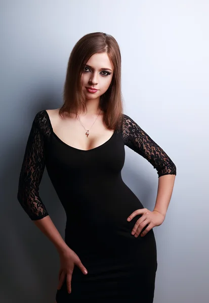 Beautiful figure woman with big bust posing in black dress