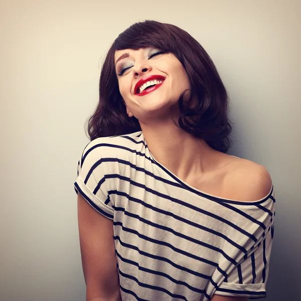 Fun laughing young woman with short hairstyle and closed eyes. V