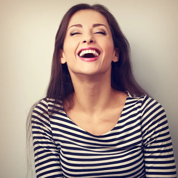 Happy natural laughing young casual woman with wide open mouth a