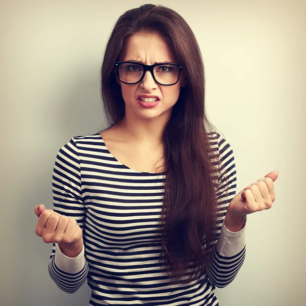 Nervous angry young woman in glasses with aggressive negative fa
