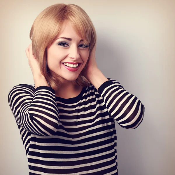 Happy toothy smiling young woman with short blond hairstyle