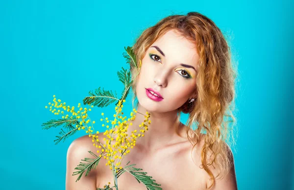 Portrait of a pretty girl with mimosa flowers.