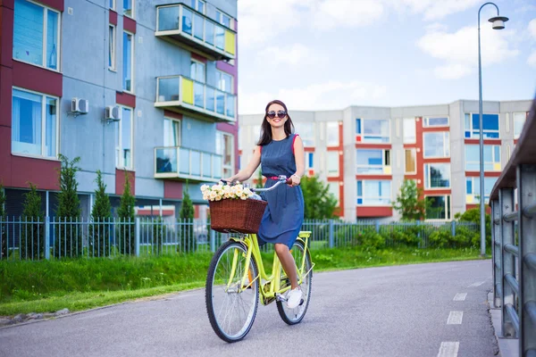 Happy woman in dress riding vintage bike