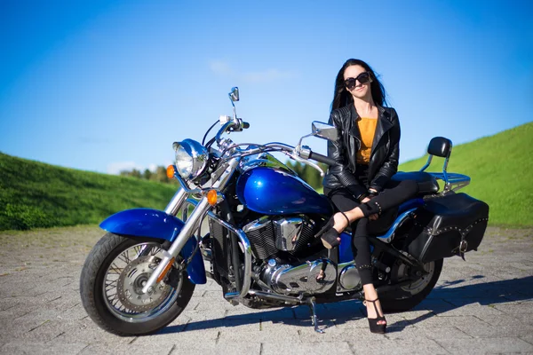 Young beautiful woman sitting on retro motorcycle