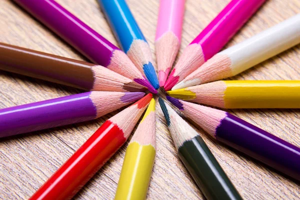 Close up of colored drawing pencils on wooden table