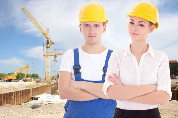 Young man builder and business woman architect in helmet