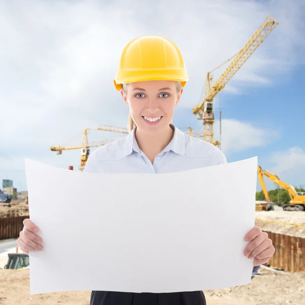Business woman architect in yellow builder helmet holding buildi