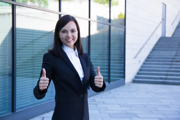 Career concept - business woman thumbs up over modern city backg