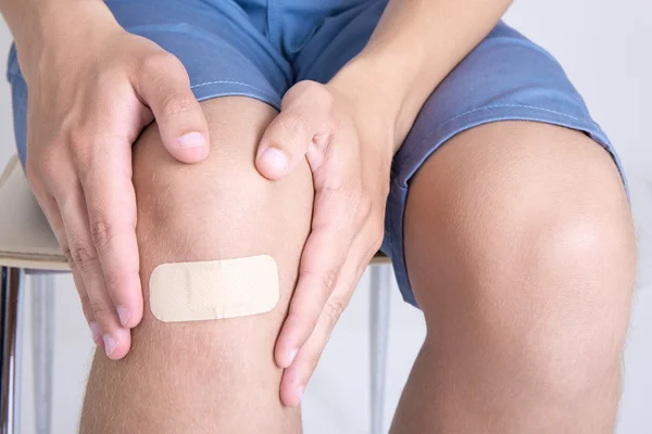 Young man with adhesive bandage on knee