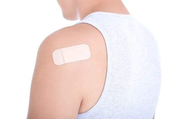 Medical adhesive patch on male shoulder isolated on white