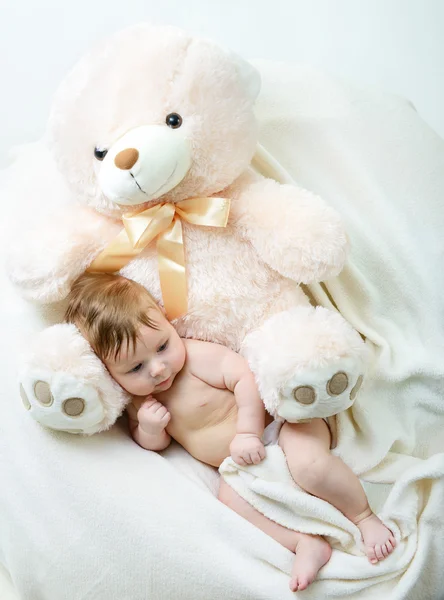 Infant baby boy with big toy bear