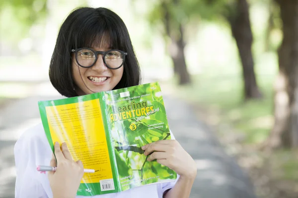 Young woman holding yellow book.