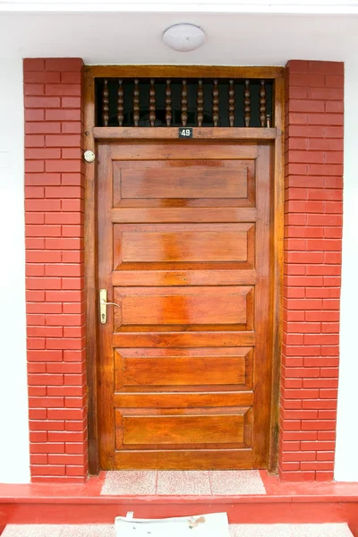 Closed ornate wood door of an upscale home, accented with an woo