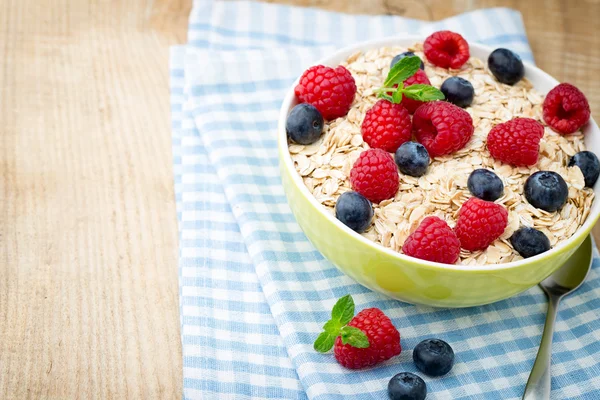 Oatmeal porridge with berries. Raspberries and blueberries.