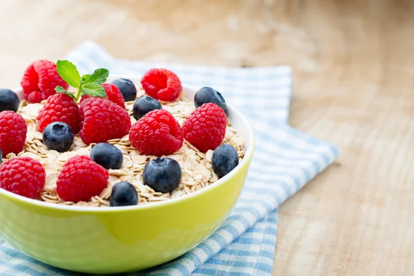 Oatmeal porridge with berries. Raspberries and blueberries.