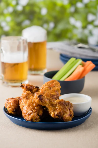 Barbecue hot chicken wings with beers at pub garden