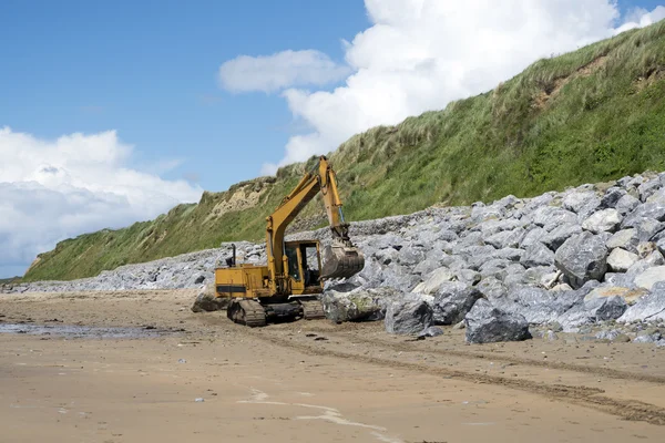 Mechanical excavator working on coastal protection