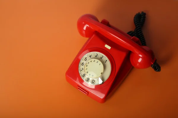 Red vintage phone on a orange background