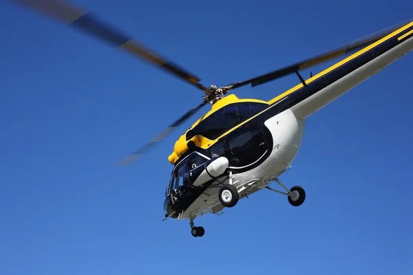 Aircraft - Black-yellow helicopter flight at low height