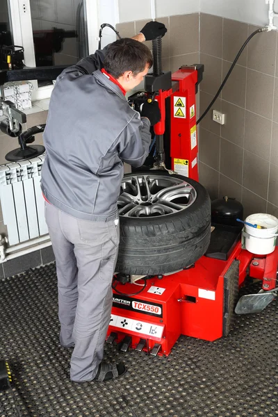 Car service. The worker repair of tires wheel