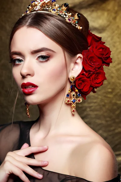 Woman with crown and red roses in hairstyle