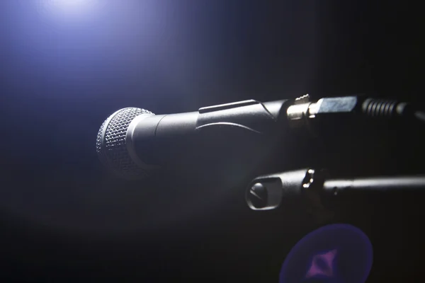 Black microphone on black dark background.