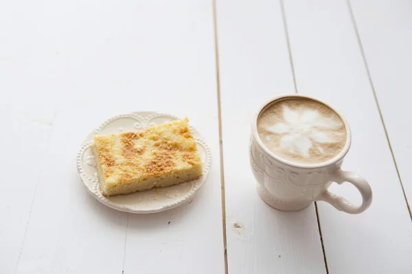 Cup of coffee with cake on dark table