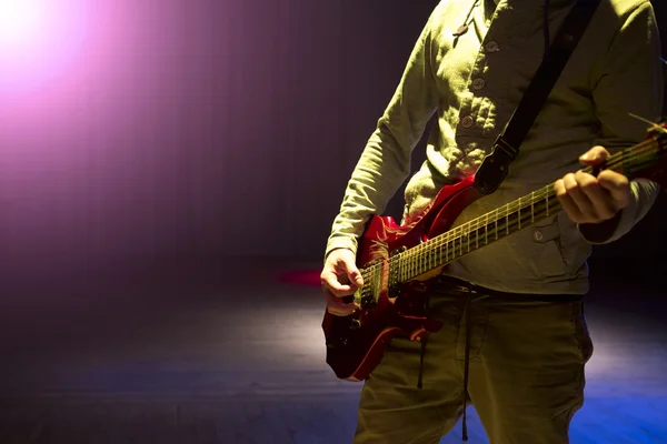 Young man playing on electric guitar