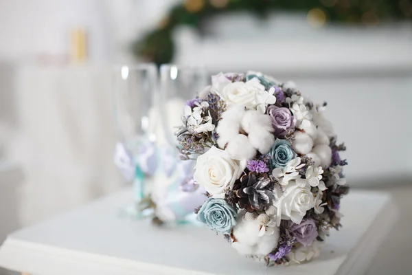 Winter wedding bouquet near glasses.