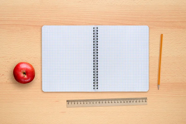 School notebook, apple, pencil and ruler on desk top view