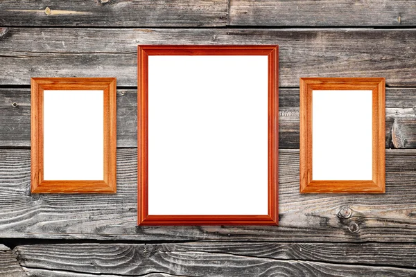 Three empty photo frames on old wooden wall