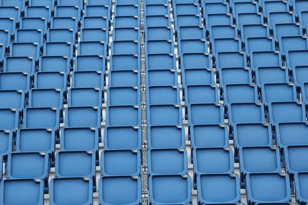 Plastic blue seats on football stadium background