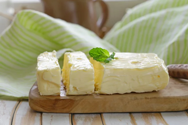 Block of fresh organic butter on a wooden board