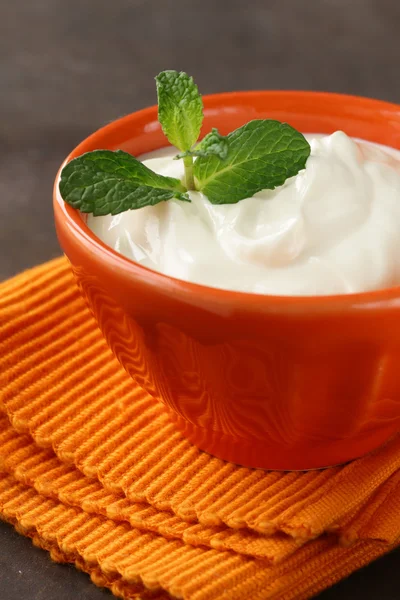 Natural organic sour cream in orange bowl
