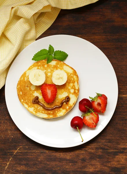 Breakfast pancakes with berries (strawberry, cherry, banana), funny face