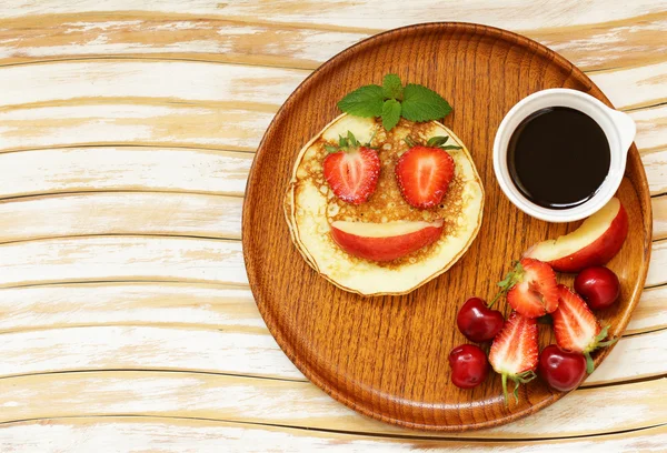 Breakfast pancakes with berries (strawberry, cherry, banana), funny face