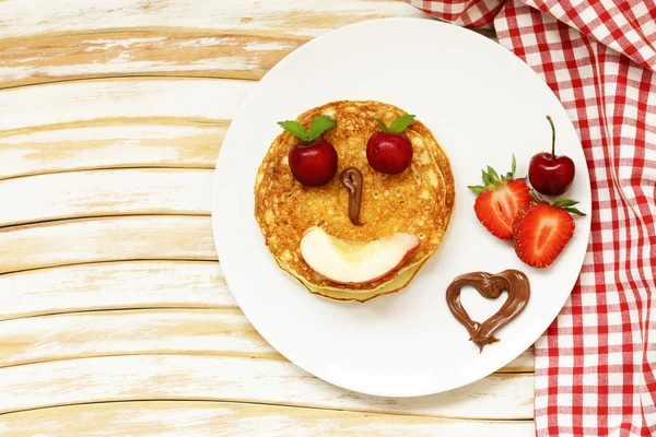 Breakfast pancakes with berries (strawberry, cherry, banana), funny face