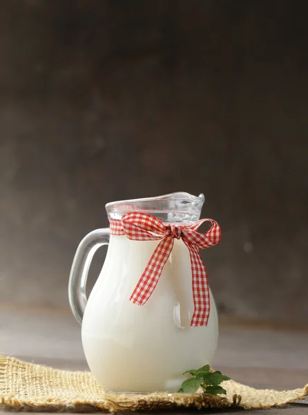Natural organic milk in a glass jar on a wooden table