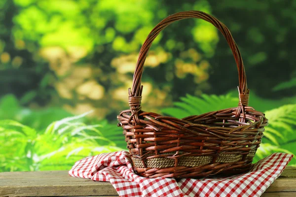 Empty wicker basket and checkered plaid for picnic
