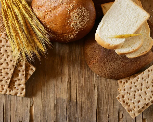 Assortment of bread (rye, whole wheat, for toast) on wooden background