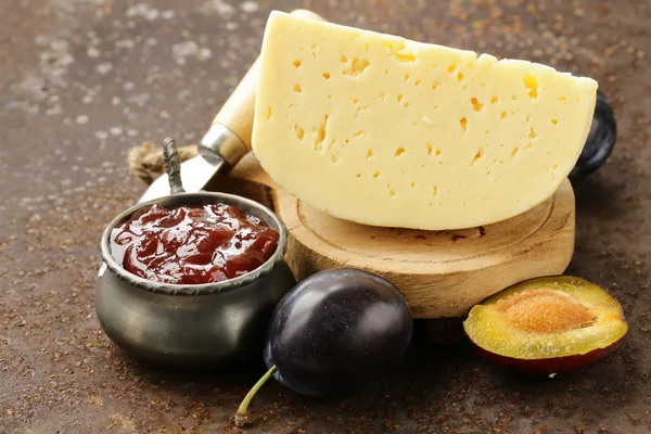 Cheese board plate with plums jam and fresh fruit