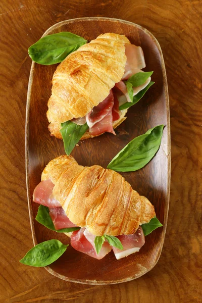 Gourmet sandwich croissant with ham and basil
