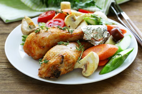 Fried chicken legs with herbs and spices, vegetables for garnish