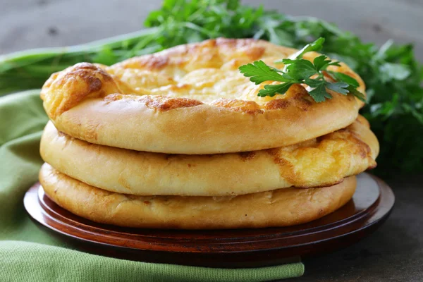 Baked flat bread with cheese on a wooden table