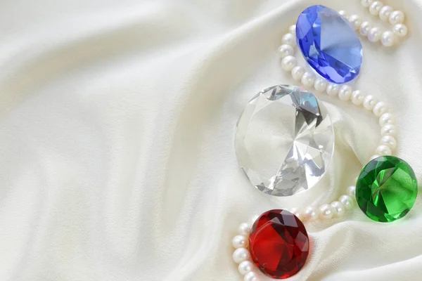 Colored glass diamonds on a soft silk background