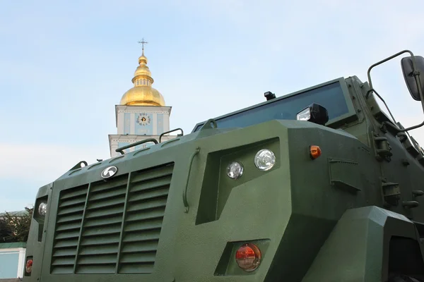 Military vehicle close-up against the church bell tower